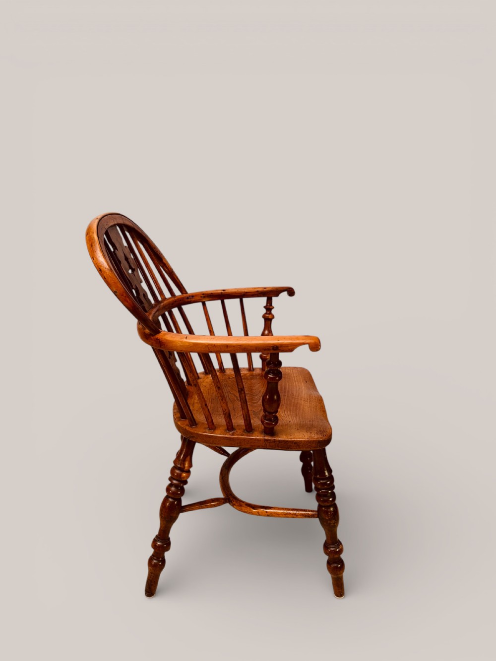 A Victorian 19th-century Windsor low back armchair constructed from yew and elm wood featuring turned legs, a pierced splat, and a contoured saddle seat. View II