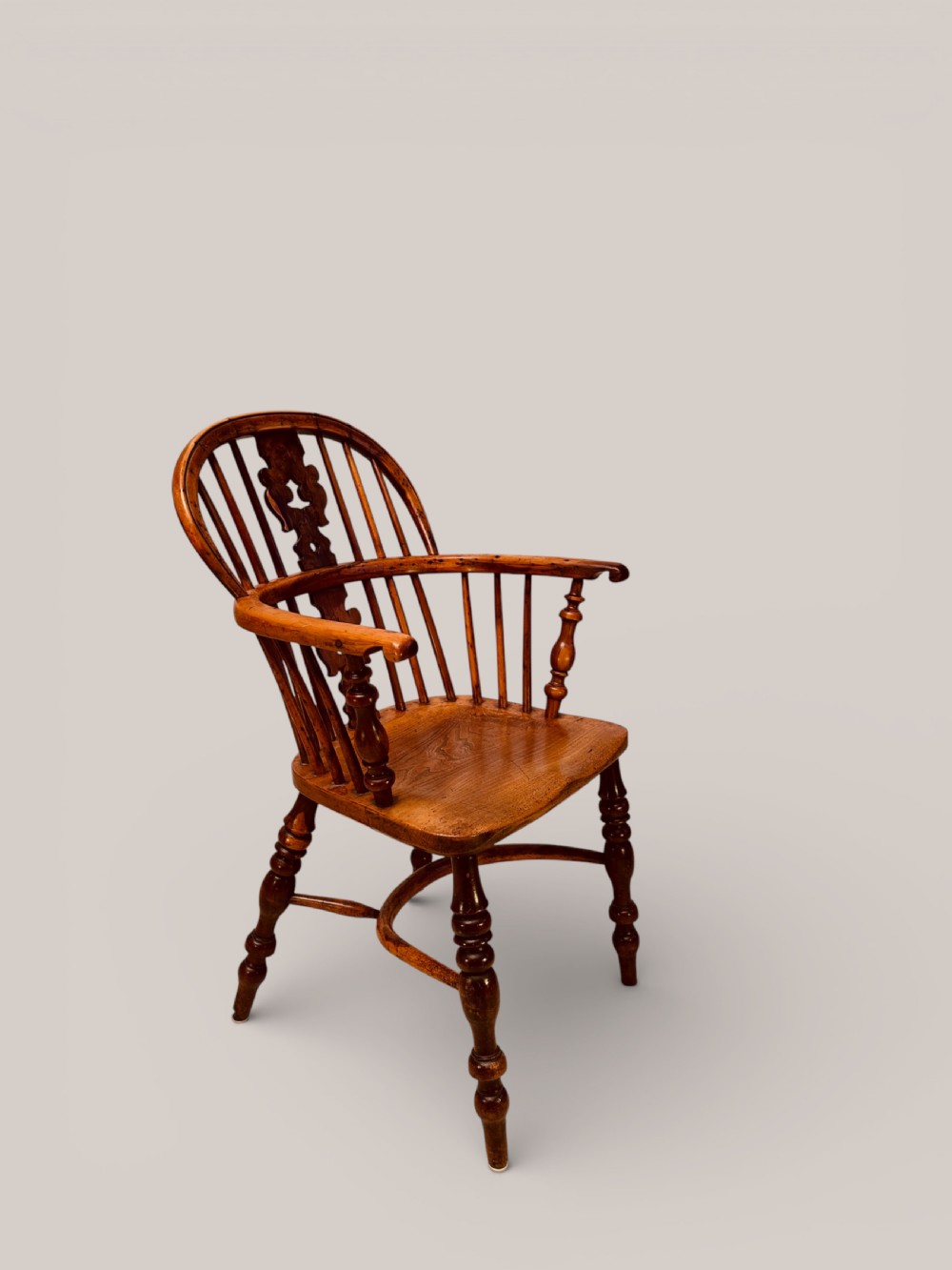 A Victorian 19th-century Windsor low back armchair constructed from yew and elm wood featuring turned legs, a pierced splat, and a contoured saddle seat. View IV