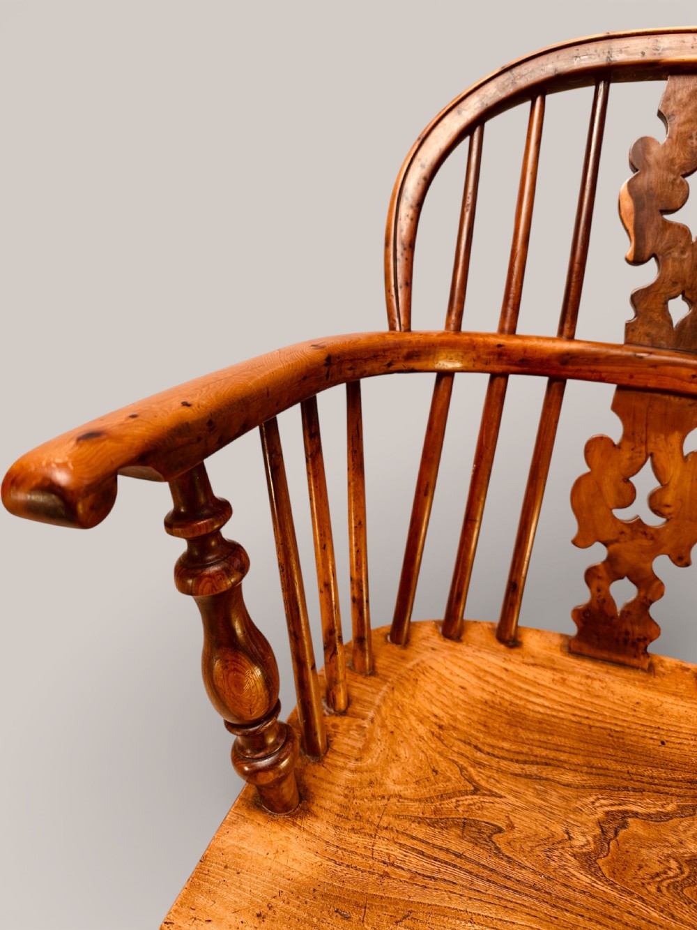 A Victorian 19th-century Windsor low back armchair constructed from yew and elm wood featuring turned legs, a pierced splat, and a contoured saddle seat. View VII