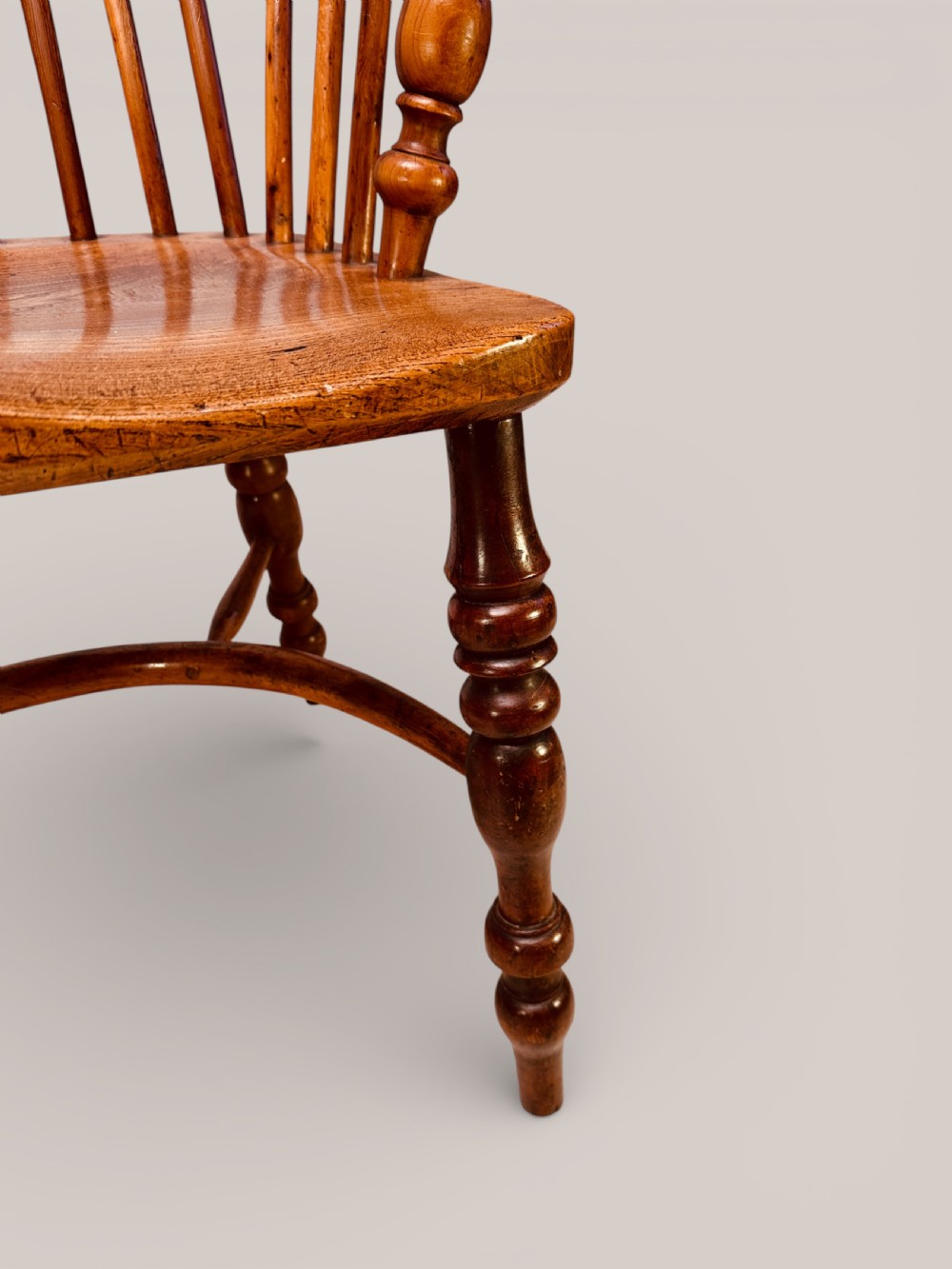 A Victorian 19th-century Windsor low back armchair constructed from yew and elm wood featuring turned legs, a pierced splat, and a contoured saddle seat. View VIII