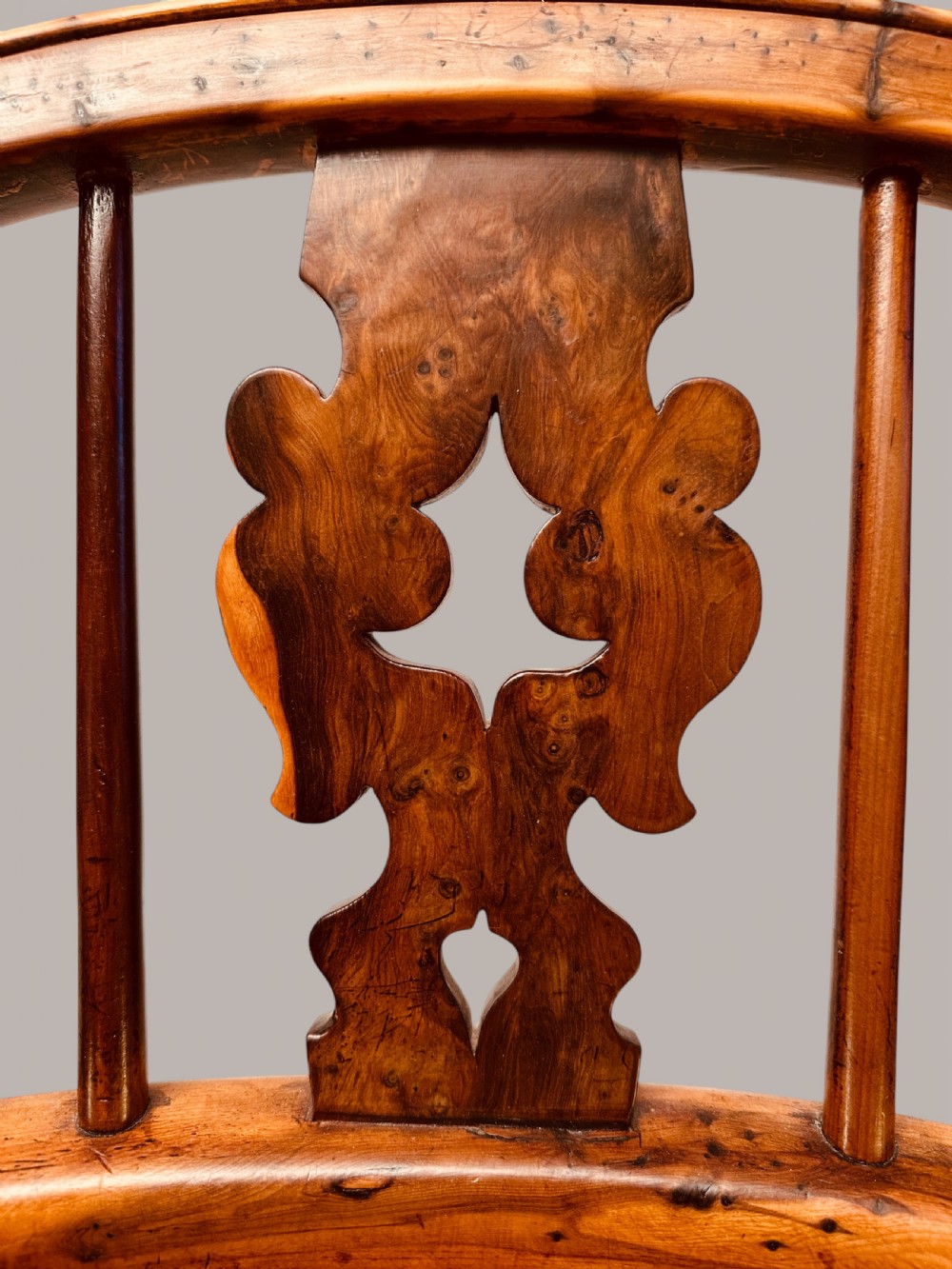 A Victorian 19th-century Windsor low back armchair constructed from yew and elm wood featuring turned legs, a pierced splat, and a contoured saddle seat. View X