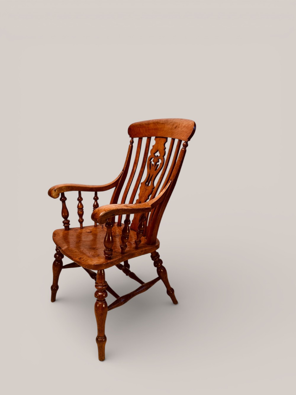 A Victorian Windsor armchair crafted from beech and elm with a pierced back splat, turned legs, and curved armrests. View II