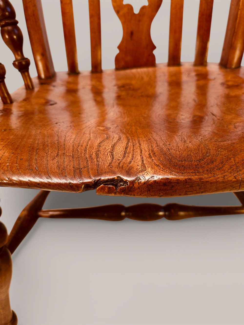 A Victorian Windsor armchair crafted from beech and elm with a pierced back splat, turned legs, and curved armrests. View X