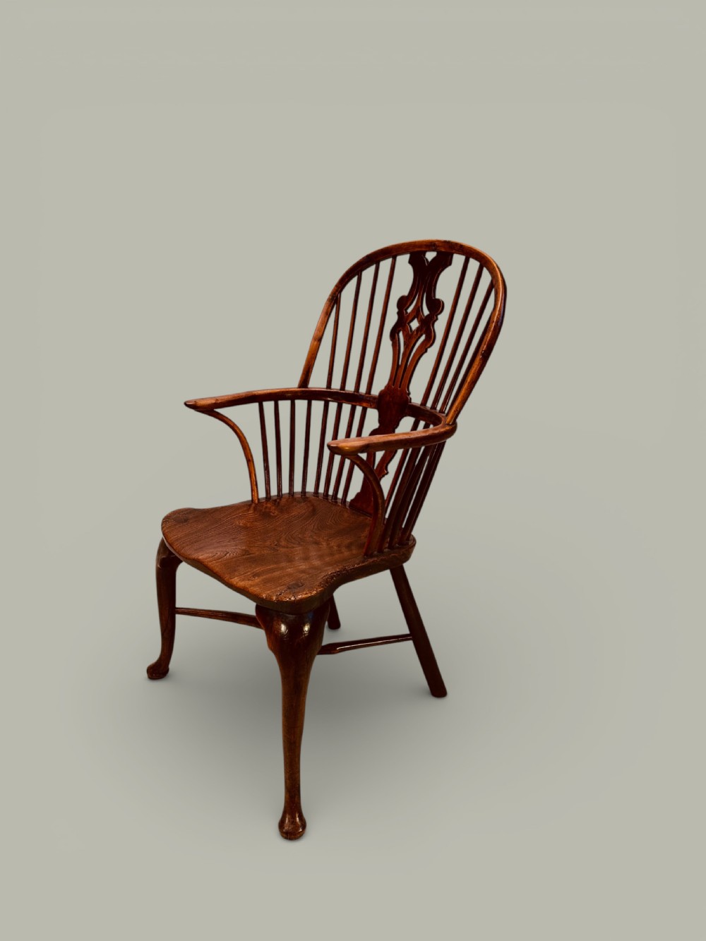 An eighteenth-century Windsor armchair crafted from yew wood and elm featuring a curved hoop back, pierced splat, shaped saddle seat, and cabriole front legs. View III