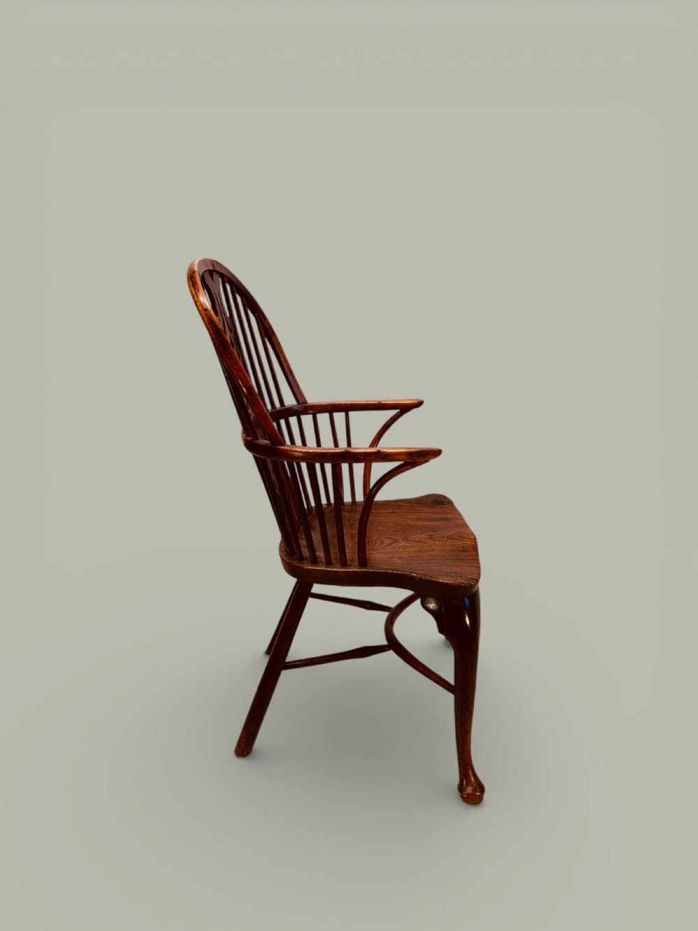 An eighteenth-century Windsor armchair crafted from yew wood and elm featuring a curved hoop back, pierced splat, shaped saddle seat, and cabriole front legs. View V