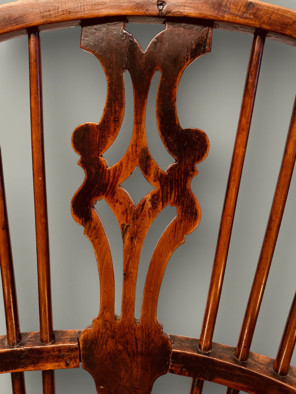 An eighteenth-century Windsor armchair crafted from yew wood and elm featuring a curved hoop back, pierced splat, shaped saddle seat, and cabriole front legs. View XIII