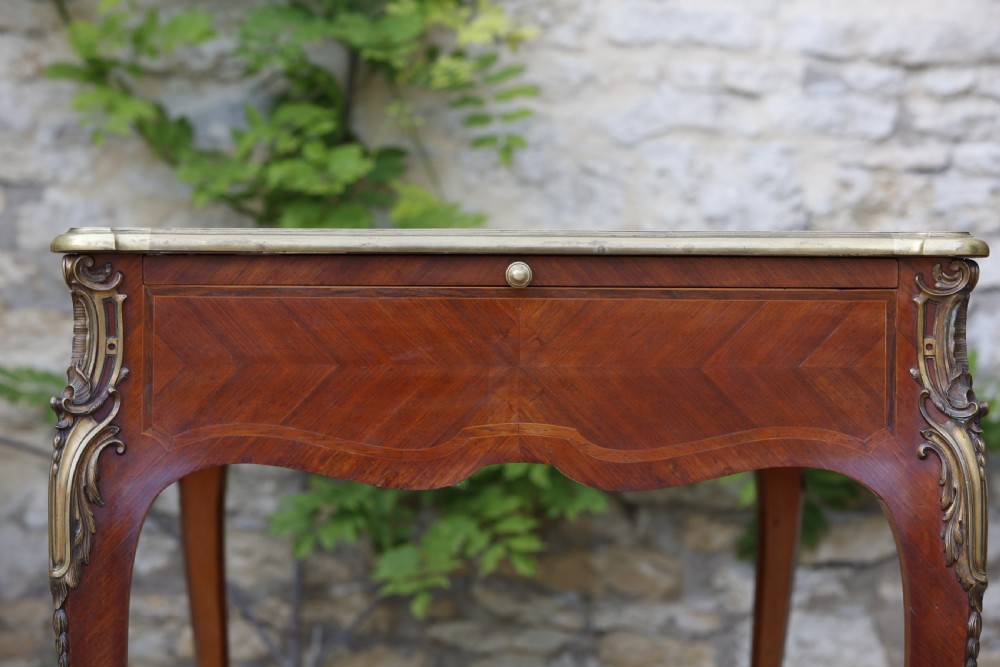 A Louis XV style bureau plat writing desk crafted from rosewood and tulipwood parquetry veneer, featuring gilt-bronze mounts, cabriole legs, three frieze drawers, and a leather-inset writing top. View VI