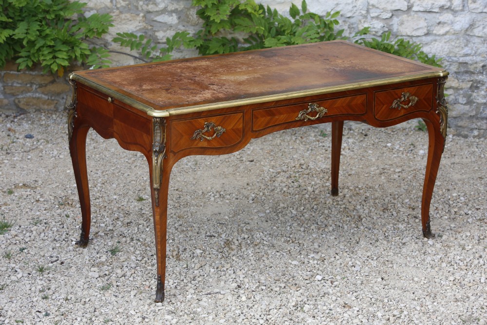 A Louis XV style bureau plat writing desk crafted from rosewood and tulipwood parquetry veneer, featuring gilt-bronze mounts, cabriole legs, three frieze drawers, and a leather-inset writing top. View XI