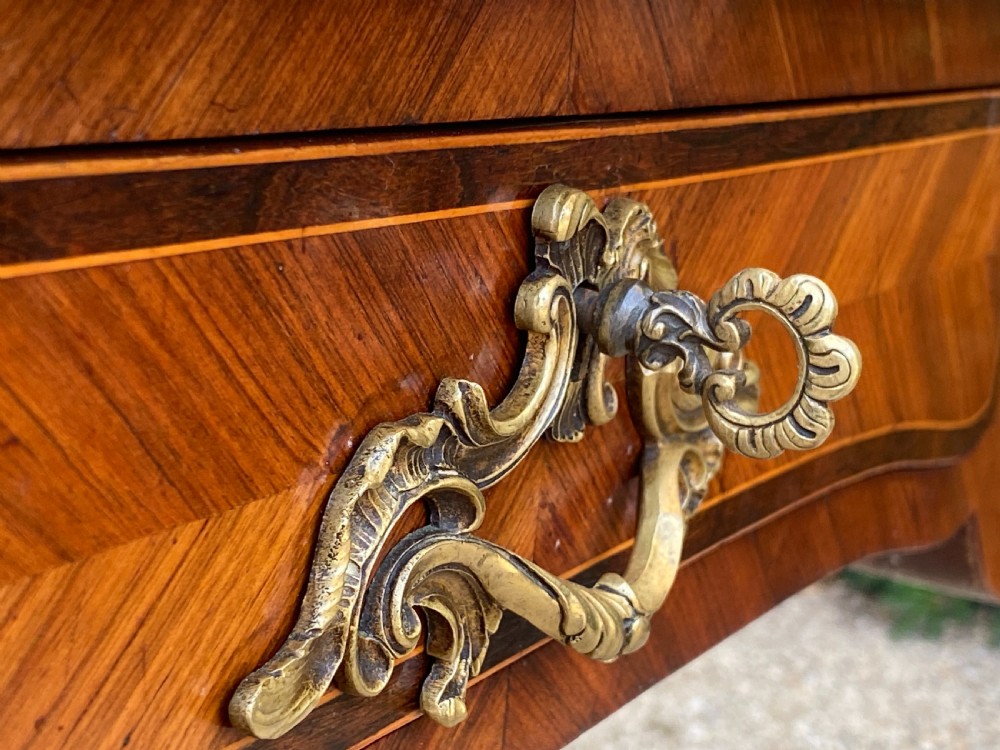 A Louis XV style bureau plat writing desk crafted from rosewood and tulipwood parquetry veneer, featuring gilt-bronze mounts, cabriole legs, three frieze drawers, and a leather-inset writing top. View XVI
