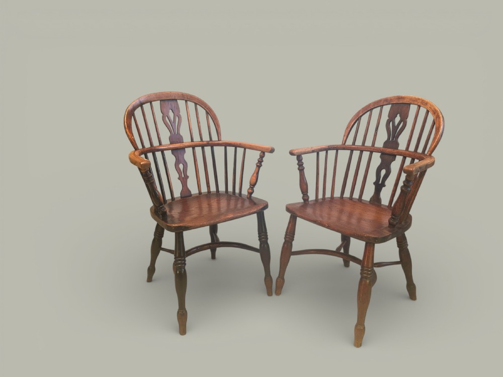 A set of twelve antique low back Windsor armchairs crafted from warm brown ash and elm with turned legs and hoop backs. View II