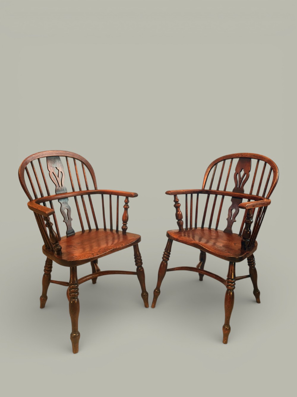 A set of twelve antique low back Windsor armchairs crafted from warm brown ash and elm with turned legs and hoop backs. View IV