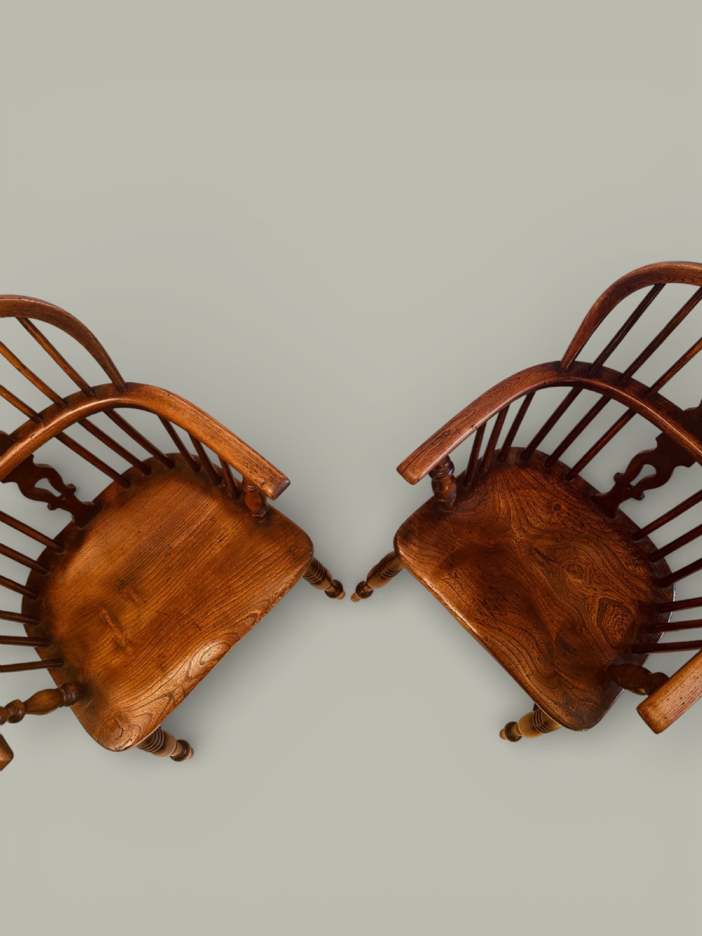 A set of twelve antique low back Windsor armchairs crafted from warm brown ash and elm with turned legs and hoop backs. View V