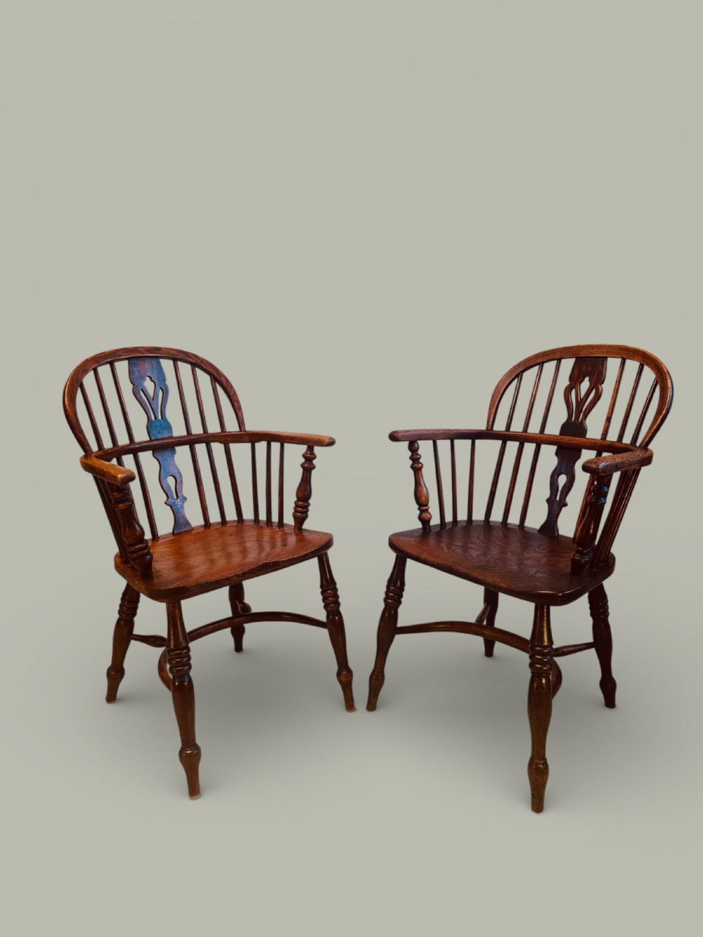 A set of twelve antique low back Windsor armchairs crafted from warm brown ash and elm with turned legs and hoop backs. View VI