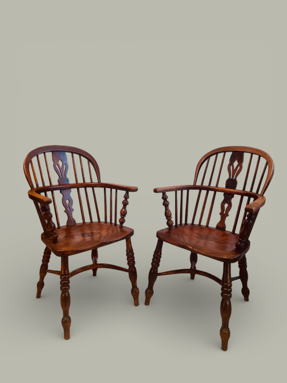 A set of twelve antique low back Windsor armchairs crafted from warm brown ash and elm with turned legs and hoop backs. View VIII