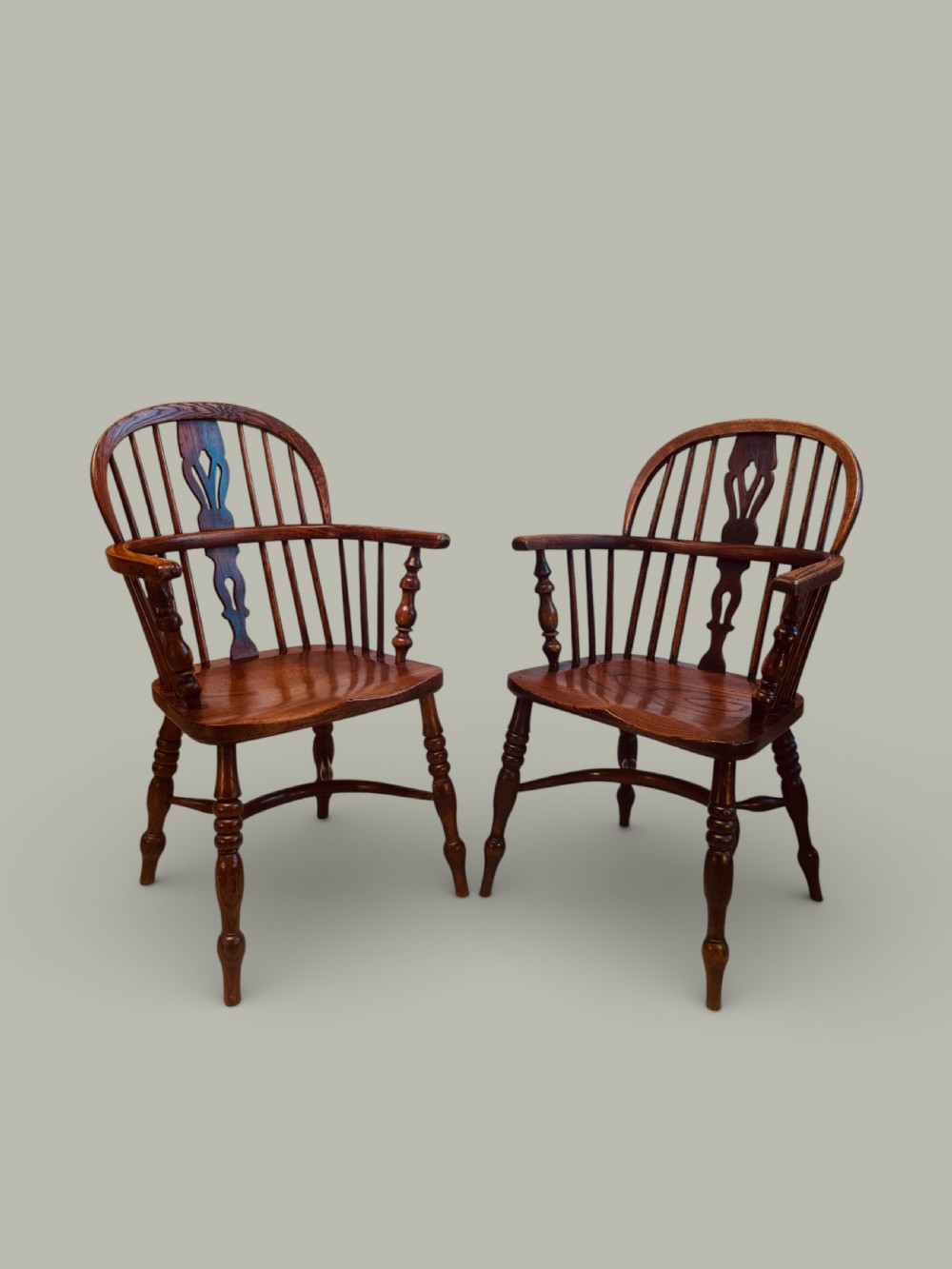 A set of twelve antique low back Windsor armchairs crafted from warm brown ash and elm with turned legs and hoop backs. View X