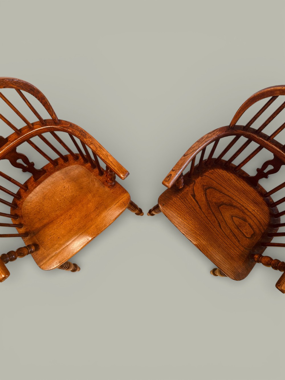 A set of twelve antique low back Windsor armchairs crafted from warm brown ash and elm with turned legs and hoop backs. View XI