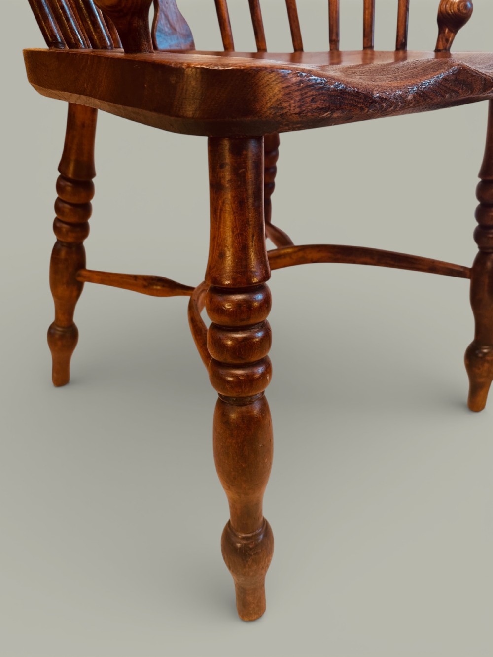 A set of twelve antique low back Windsor armchairs crafted from warm brown ash and elm with turned legs and hoop backs. View XVIII