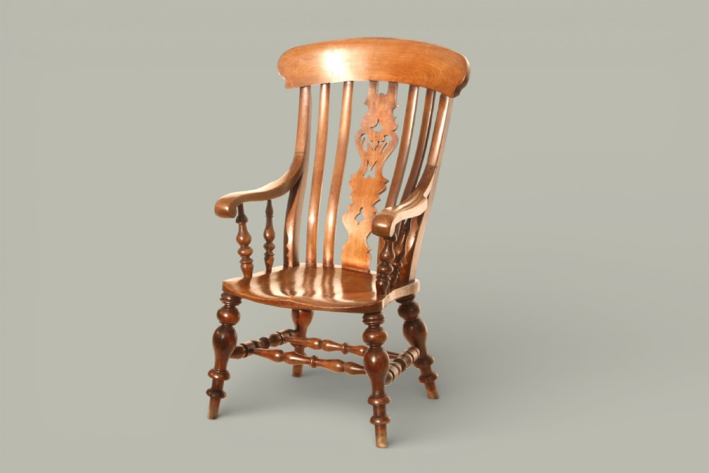 A late 19th-century Victorian Windsor armchair made from fruitwood and elm with a pierced back splat, turned legs, and a shaped seat.