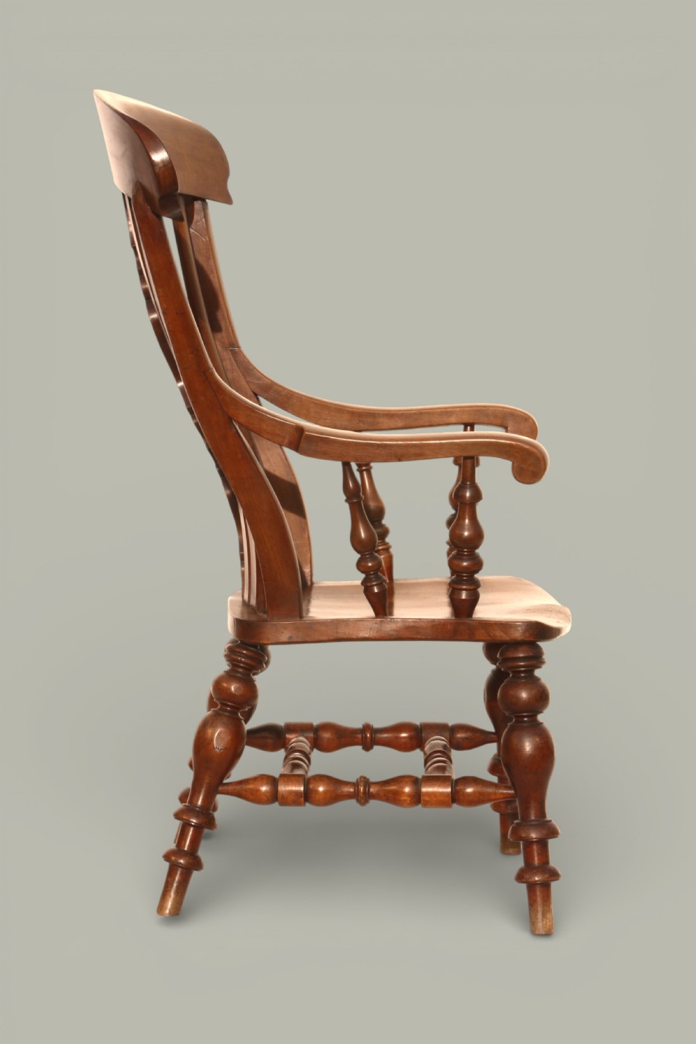 A late 19th-century Victorian Windsor armchair made from fruitwood and elm with a pierced back splat, turned legs, and a shaped seat. View V