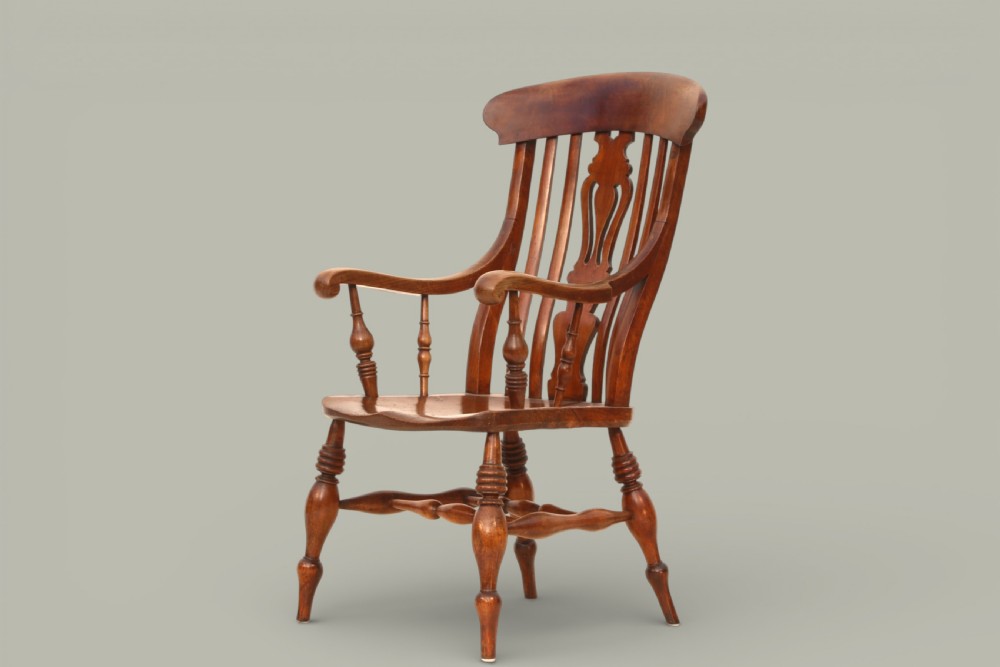 A late nineteenth-century Windsor armchair crafted from warm brown fruitwood and elm with turned legs, curved arms, and a central splat back. View II