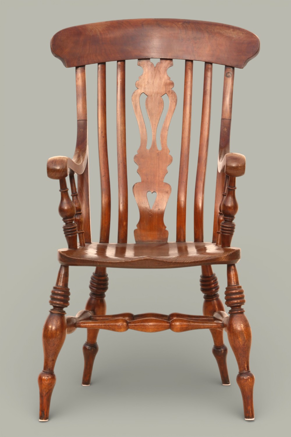 A late nineteenth-century Windsor armchair crafted from warm brown fruitwood and elm with turned legs, curved arms, and a central splat back. View III