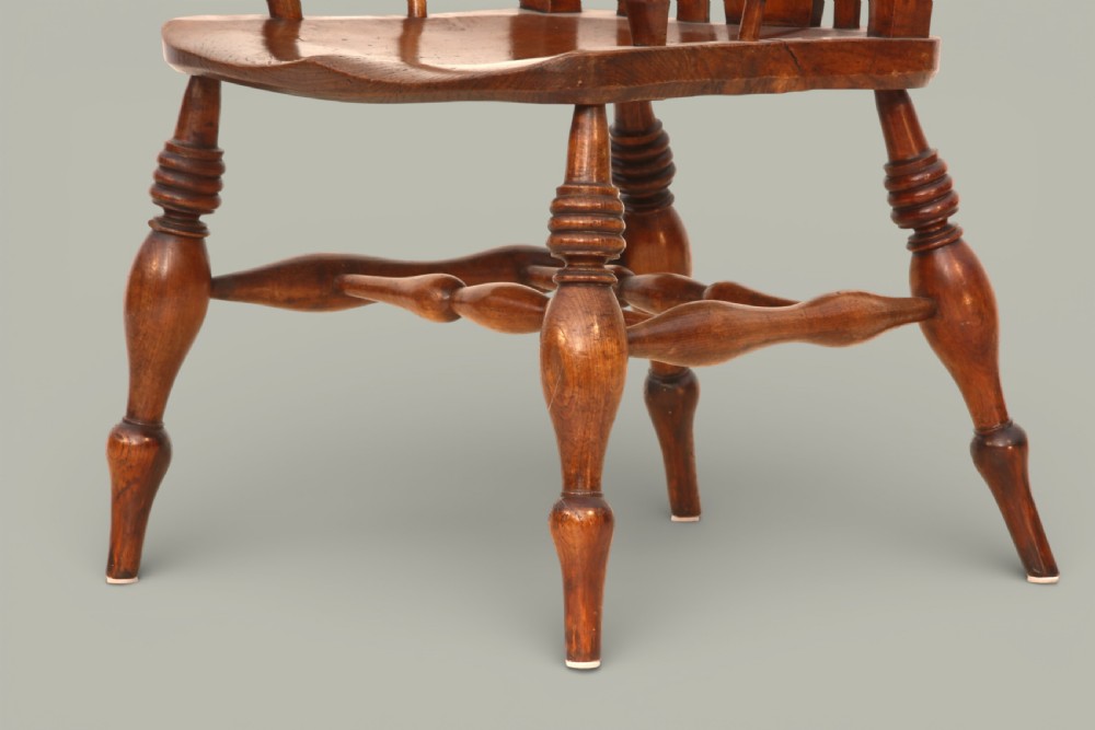 A late nineteenth-century Windsor armchair crafted from warm brown fruitwood and elm with turned legs, curved arms, and a central splat back. View VI