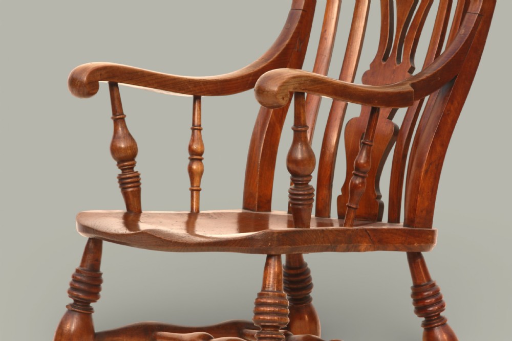 A late nineteenth-century Windsor armchair crafted from warm brown fruitwood and elm with turned legs, curved arms, and a central splat back. View VII