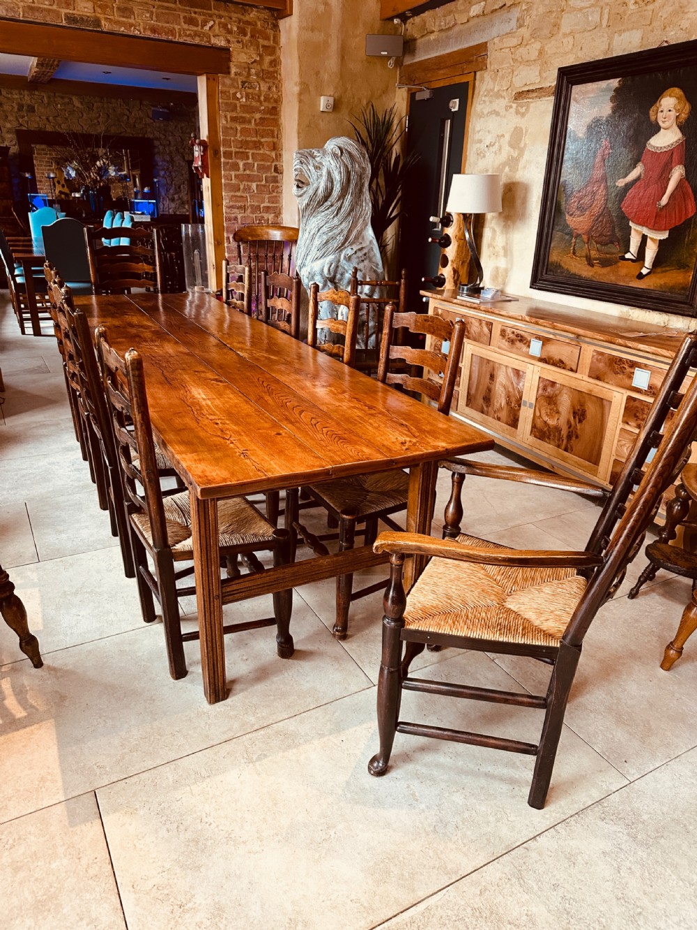 A long French elm farmhouse dining table featuring a three-plank wooden top with prominent grain patterns and square legs. View IV