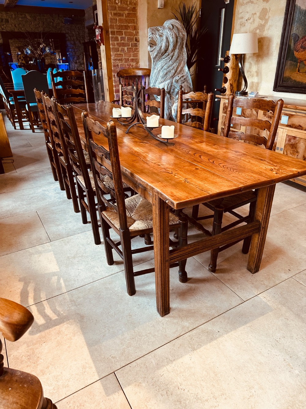 A long French elm farmhouse dining table featuring a three-plank wooden top with prominent grain patterns and square legs. View VII