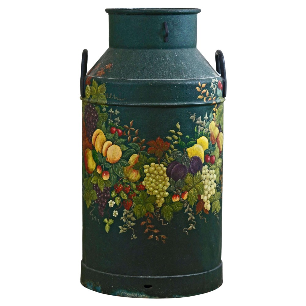 A dark green metal milk churn decorated with hand-painted fruit and foliage, featuring two side handles and repurposed as a decorative stand.