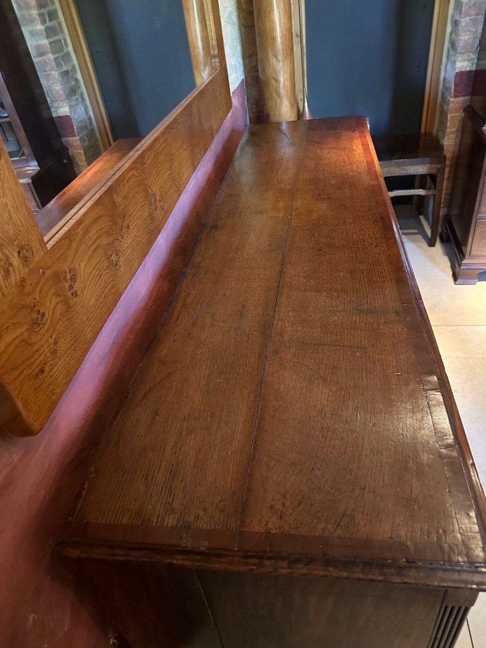 A Georgian oak Lancashire dresser base circa 1800 featuring drawer configuration, central cupboard doors with oval mahogany inlays, and brass handles. View XI