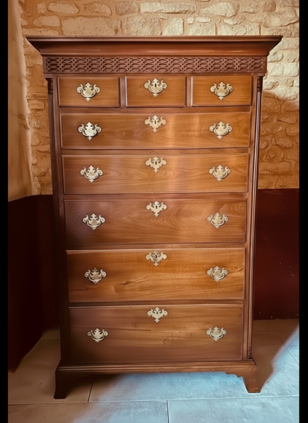 A tall Victorian walnut chest of drawers featuring three upper small drawers above five graduated full-width drawers with ornate brass handles.