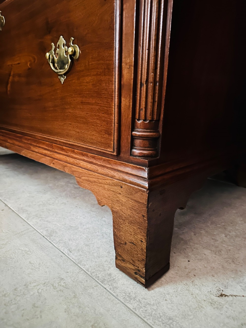 A tall Victorian walnut chest of drawers featuring three upper small drawers above five graduated full-width drawers with ornate brass handles. View IV
