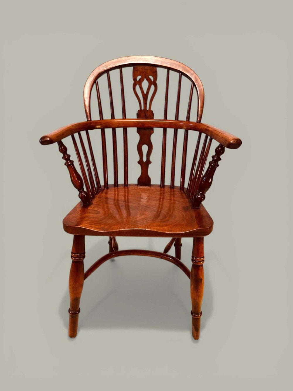 A mid-19th-century Windsor armchair crafted from polished yew and elm wood, featuring a hoop back, a pierced central splat, swept arms, and turned legs. View III