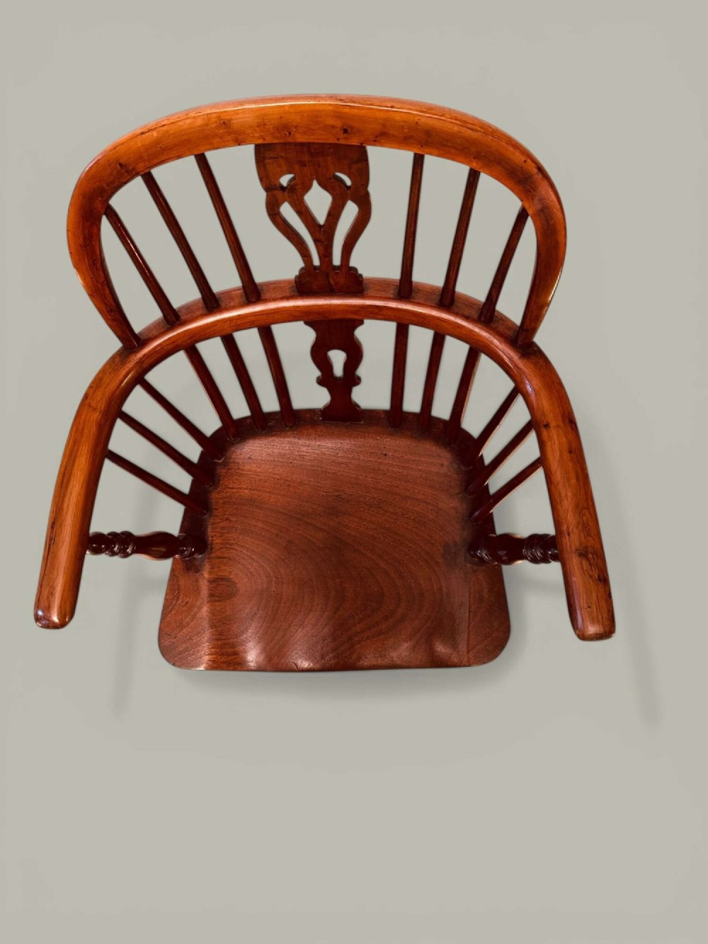 A mid-19th-century Windsor armchair crafted from polished yew and elm wood, featuring a hoop back, a pierced central splat, swept arms, and turned legs. View IV