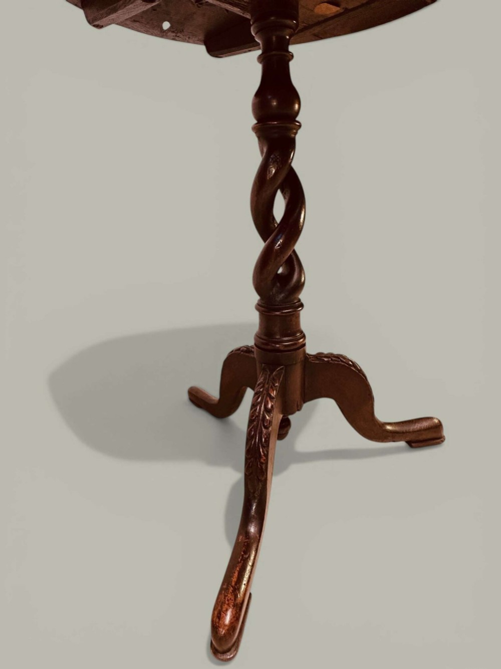 An antique dark oak circular tilt-top pedestal table featuring a geometric inlaid border, a spiral turned column, and carved tripod legs. View IV