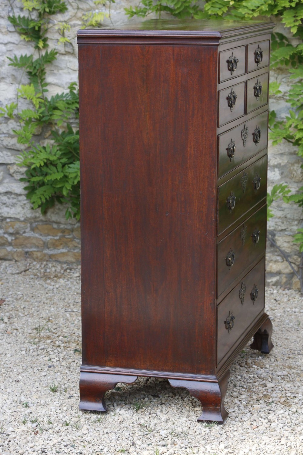 An eighteenth-century Georgian mahogany tall chest of drawers featuring brass handles, keyhole escutcheons, and ogee bracket feet. View VI