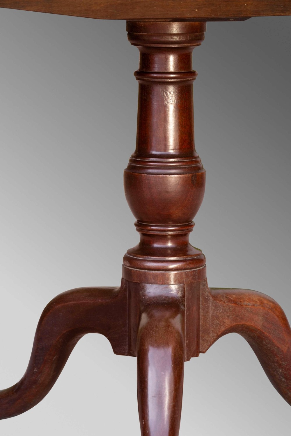 An 18th-century George III mahogany tilt-top table with a circular top raised vertically on a turned stem and splayed tripod cabriole legs. View V