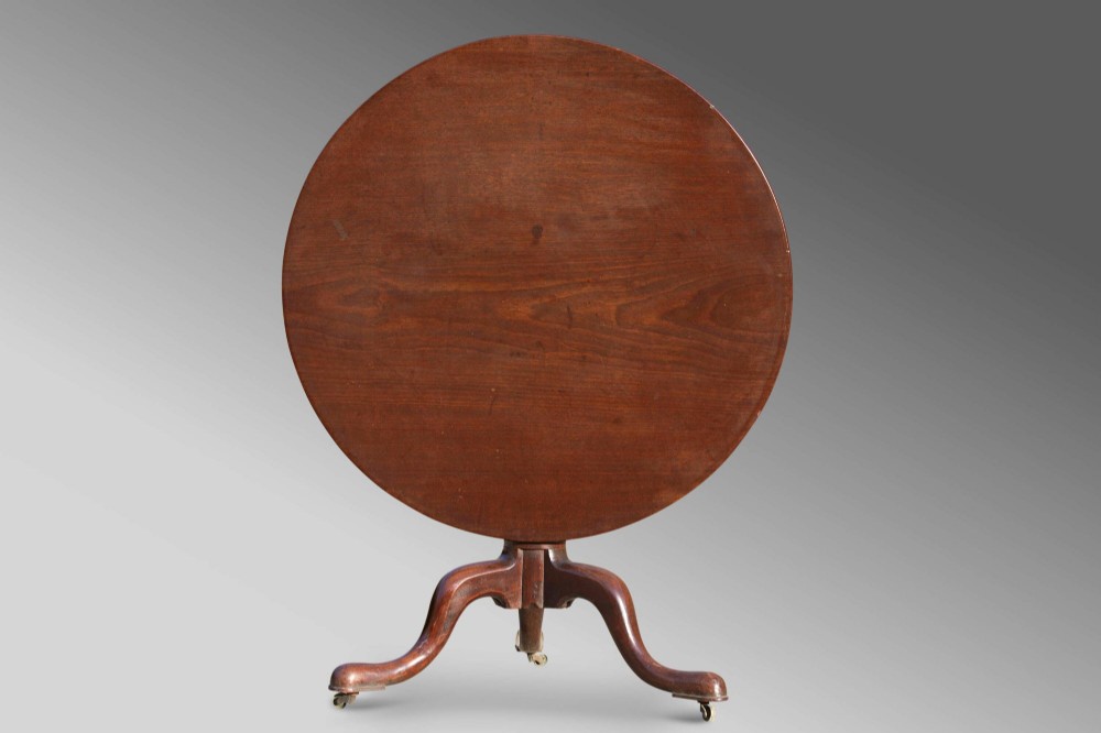 An 18th-century George III mahogany tilt-top table with a circular top raised vertically on a turned stem and splayed tripod cabriole legs. View VI