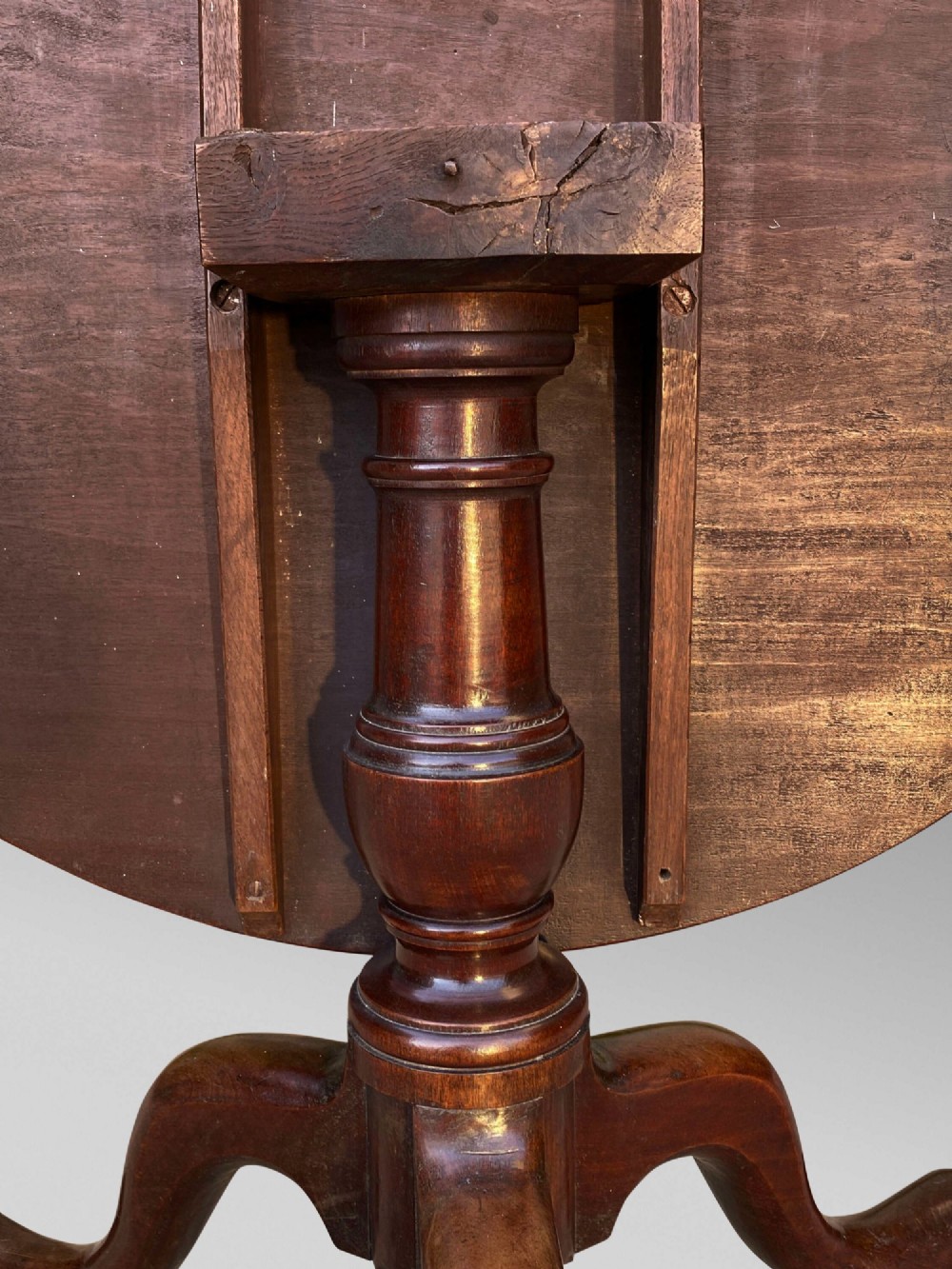 An 18th-century George III mahogany tilt-top table with a circular top raised vertically on a turned stem and splayed tripod cabriole legs. View VII