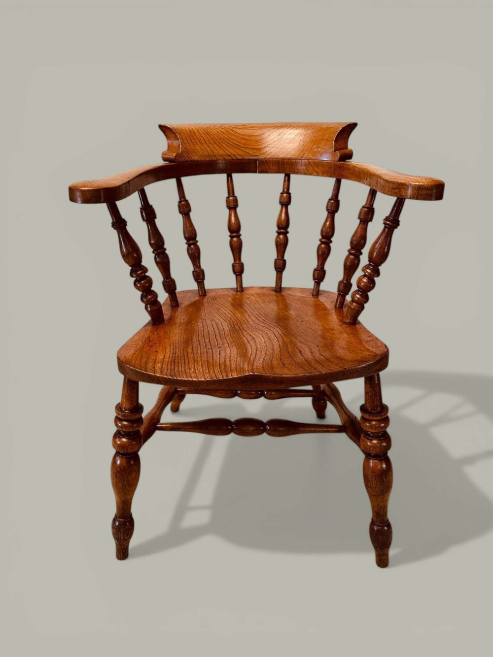 A low-backed wooden Windsor armchair crafted from ash and elm with turned spindles, a curved horseshoe armrest, and a shaped saddle seat. View II