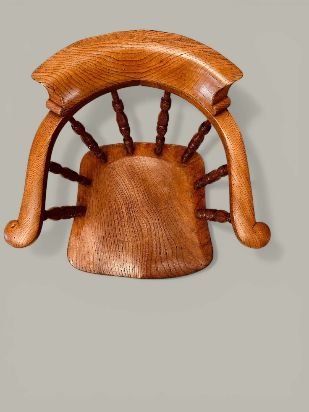 A low-backed wooden Windsor armchair crafted from ash and elm with turned spindles, a curved horseshoe armrest, and a shaped saddle seat. View VI