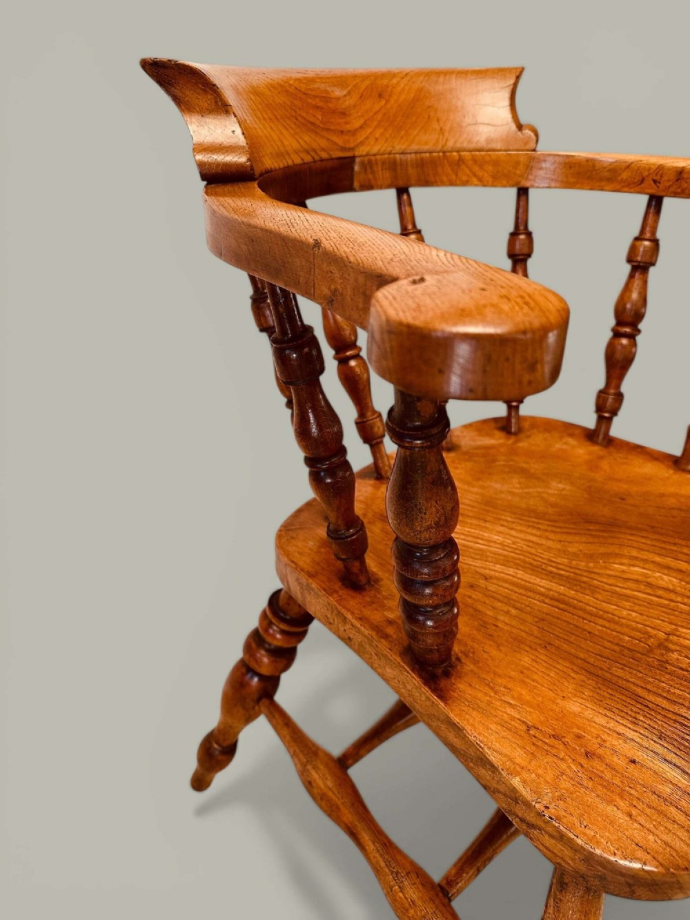A low-backed wooden Windsor armchair crafted from ash and elm with turned spindles, a curved horseshoe armrest, and a shaped saddle seat. View VIII