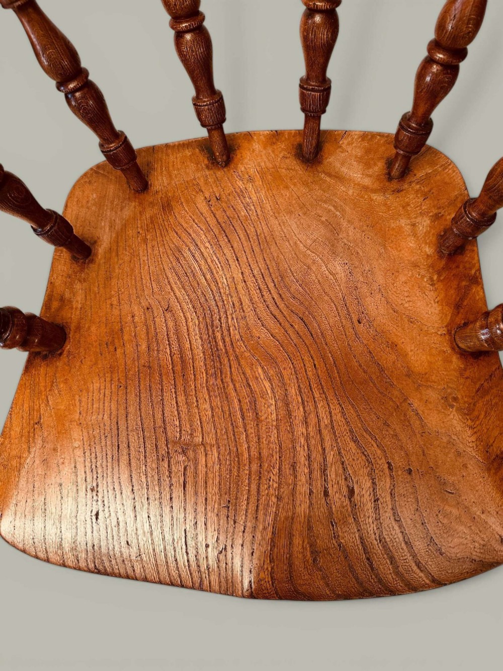 A low-backed wooden Windsor armchair crafted from ash and elm with turned spindles, a curved horseshoe armrest, and a shaped saddle seat. View XII