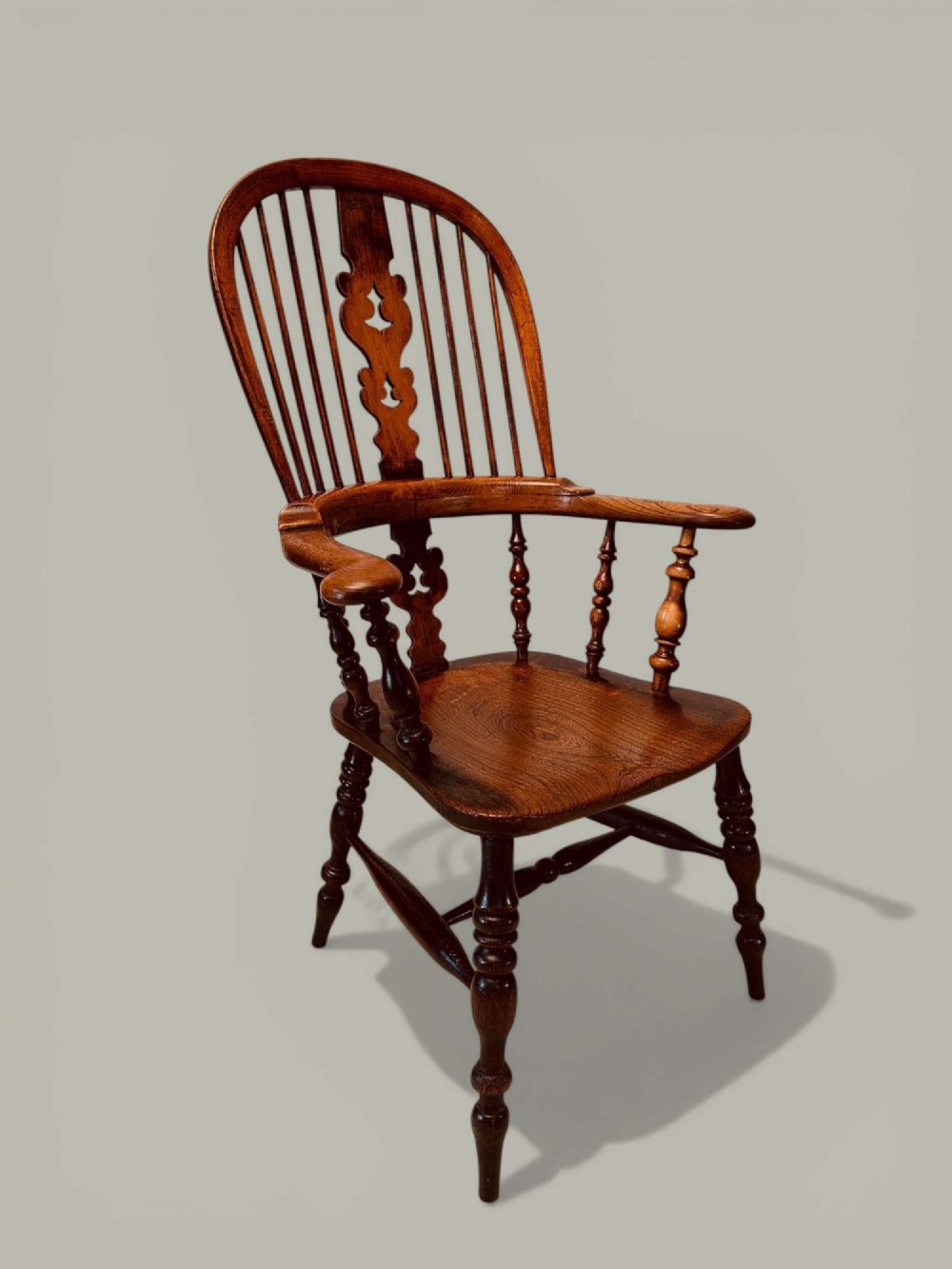 A late nineteenth-century Windsor armchair crafted from ash and elm with a hoop back, decorative pierced splat, broad armrests, and turned legs. View III