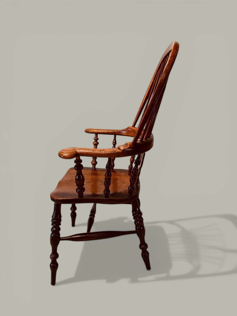 A late nineteenth-century Windsor armchair crafted from ash and elm with a hoop back, decorative pierced splat, broad armrests, and turned legs. View VI