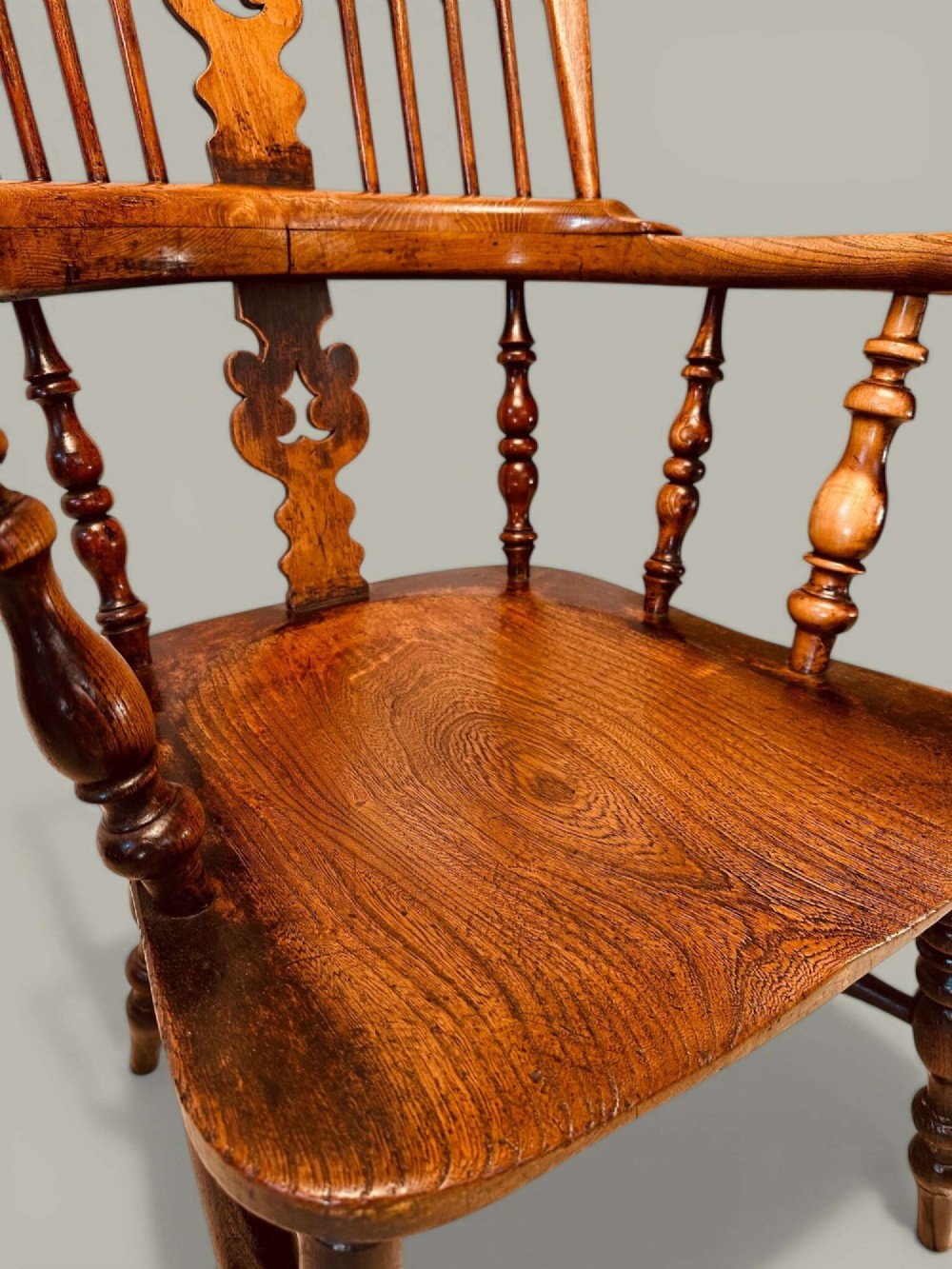 A late nineteenth-century Windsor armchair crafted from ash and elm with a hoop back, decorative pierced splat, broad armrests, and turned legs. View VIII