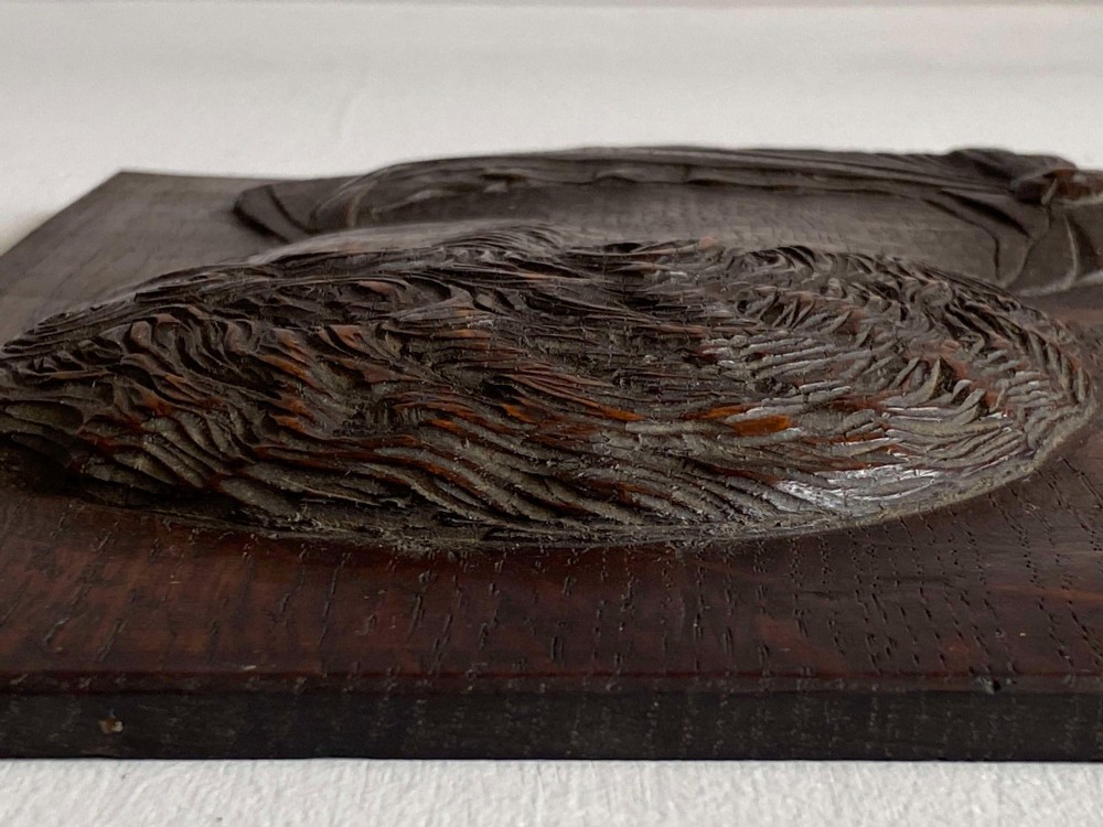 A rectangular dark oak panel featuring a high-relief carving of a Roman emperor profile in profile view. View VI