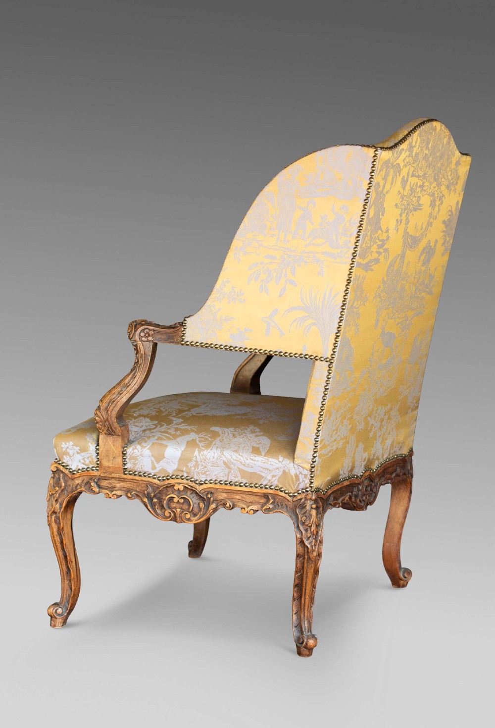 A 19th-century French Louis XV style wingback armchair with carved wood framing, cabriole legs, and gold pattern damask upholstery. View III