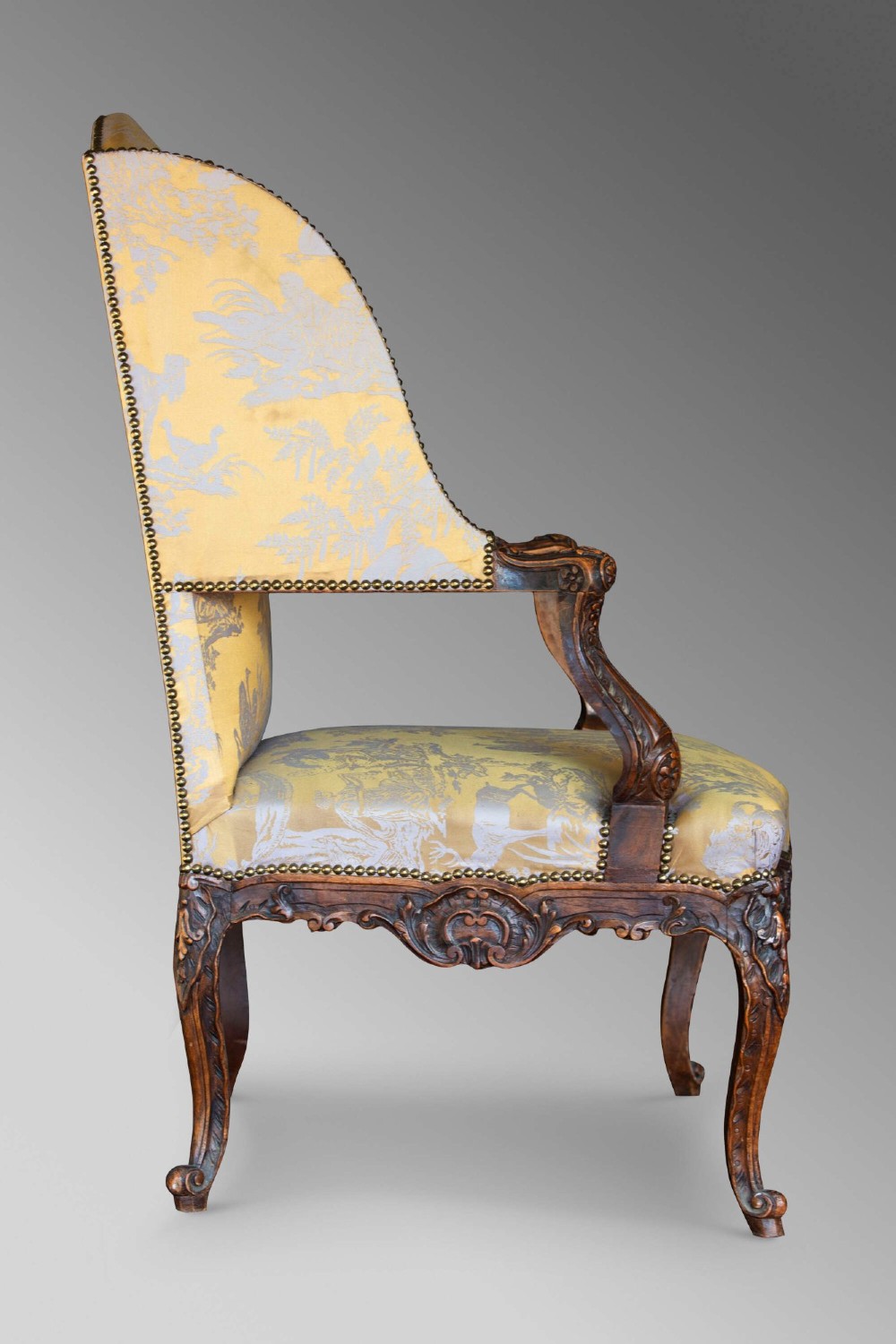 A 19th-century French Louis XV style wingback armchair with carved wood framing, cabriole legs, and gold pattern damask upholstery. View VI